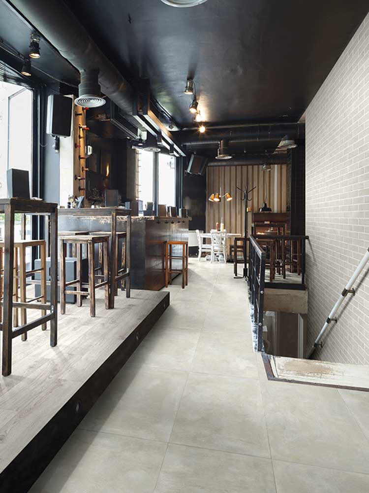 Bar con pavimento in piastrelle in gres porcellanato della Cotto Petrus, della serie Prestige